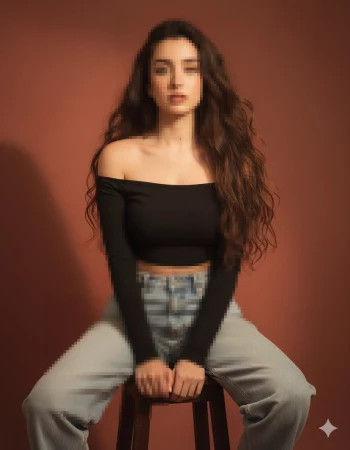 Woman in black off shoulder top and jeans sitting confidently on stool