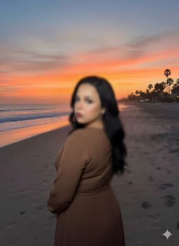 Woman in Brown Dress Posing on Beach at Sunset with Colorful Sky