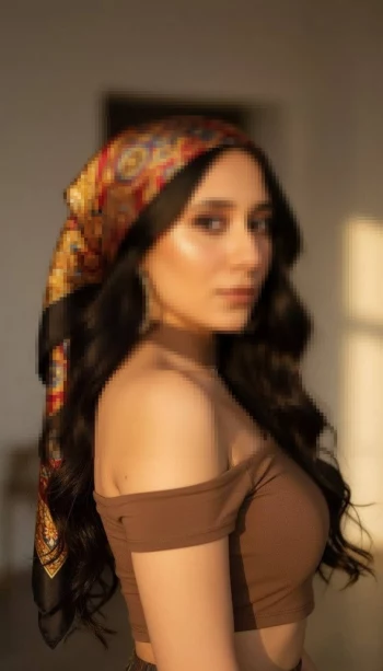 Woman in brown outfit wearing patterned silk headscarf under golden sunlight