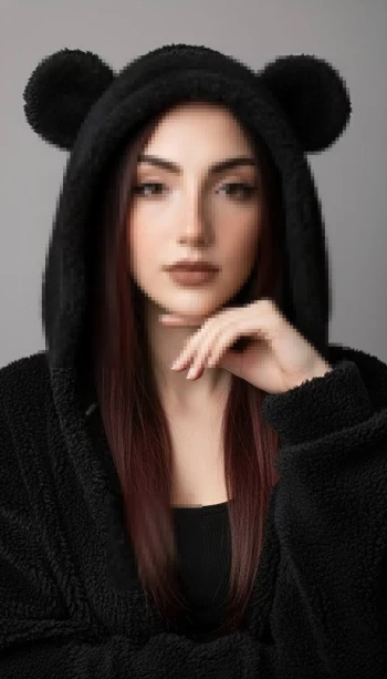 Woman in cozy black hoodie with bear ears posing against grey background