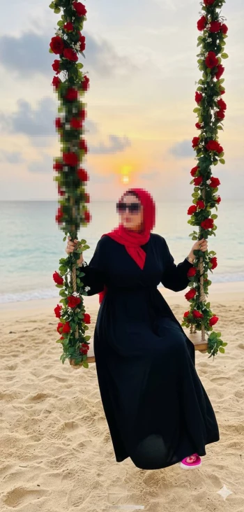 Woman in Red Headscarf on Floral Swing at Sunset Beach
