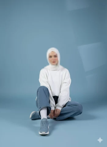 Woman in White Hijab and Casual Outfit Sitting in Minimalist Blue Studio