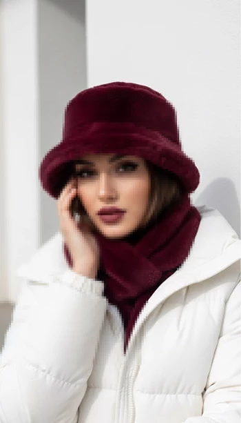 Woman in white winter jacket with burgundy hat and scarf posing elegantly